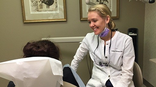 Dental team member smiling at dentistry patient