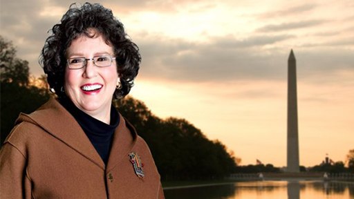 woman smiling wearing a brown coat