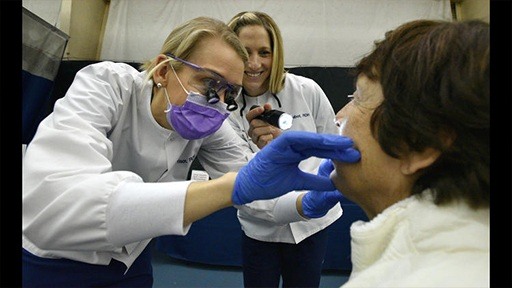 Team members performing oral cancer screening
