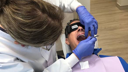 A hygienist performing oral cancer screening in Millersville 