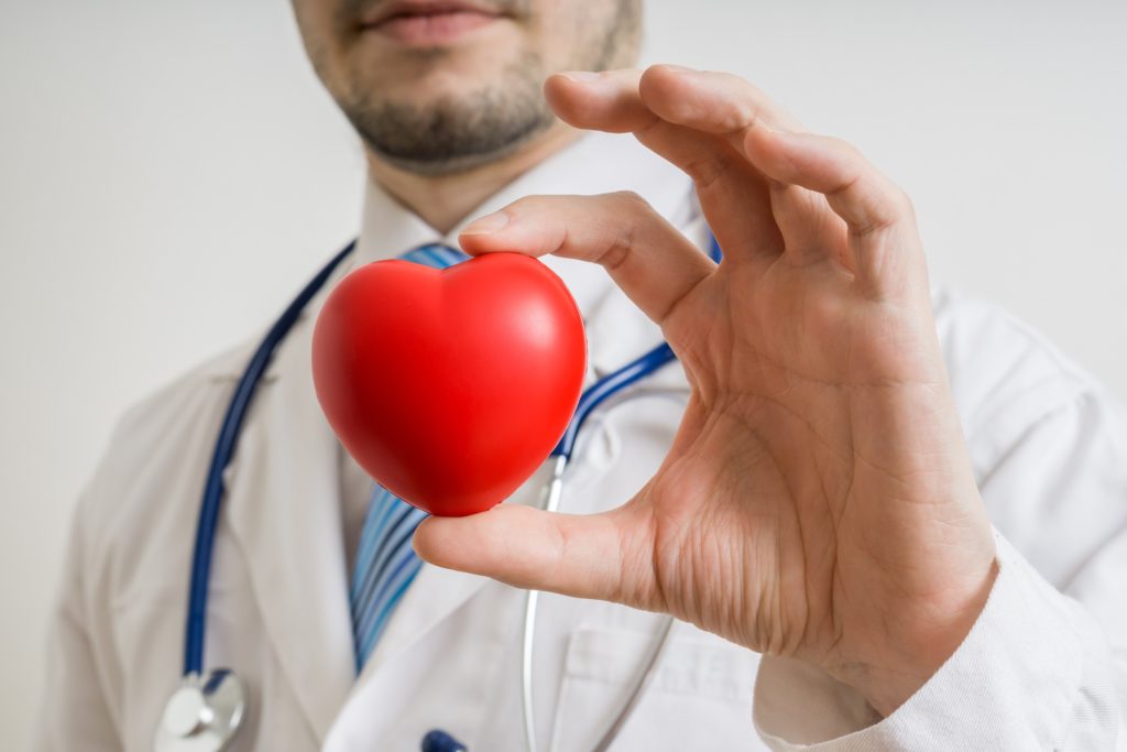 Doctor holding up a red heart